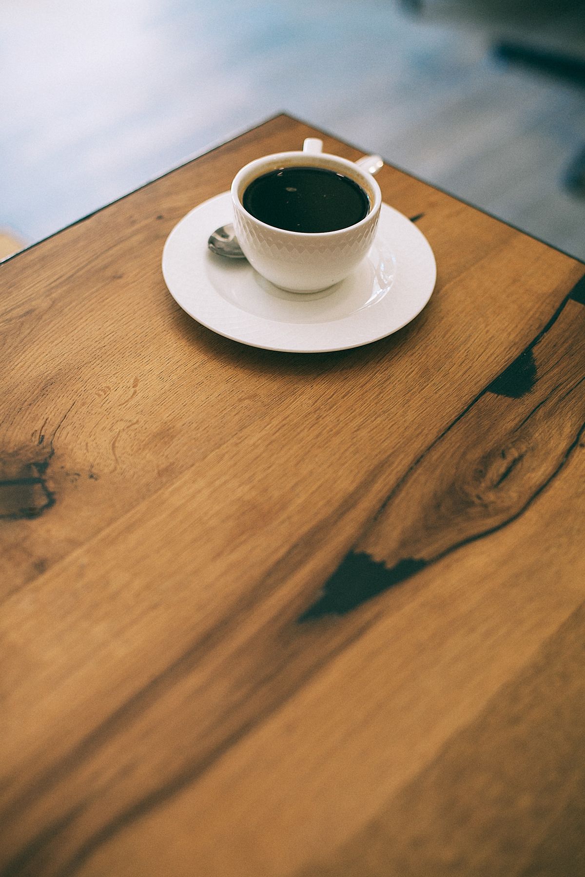 木のテーブルに置かれた一杯のコーヒー